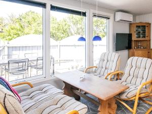een woonkamer met stoelen en een houten tafel bij 4 person holiday home in L kken in Løkken