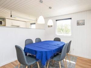 een eetkamer met een blauwe tafel en stoelen bij 4 person holiday home in L kken in Løkken