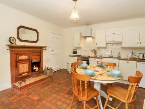 Kilmartin的住宿－2 Tayness，厨房配有桌椅和壁炉。
