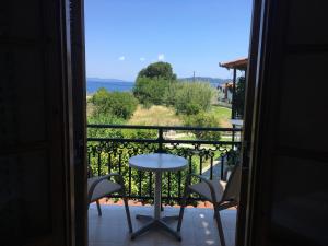 a room with a balcony with a table and chairs at Vontzos Hotel in Achladies