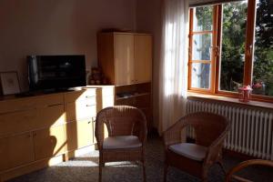 a living room with two chairs and a television and a dresser at Ferienwohnung in Seenähe in Borgdorf-Seedorf