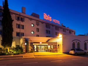 ein Hotel mit einem davor geparkt in der Unterkunft Hotel ibis Faro Algarve in Faro