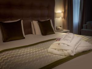 a bedroom with a bed with towels on it at Mercure Shrewsbury Albrighton Hall Hotel & Spa in Shrewsbury