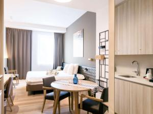a hotel room with a bed and a table and a kitchen at Mercure Roeselare in Roeselare