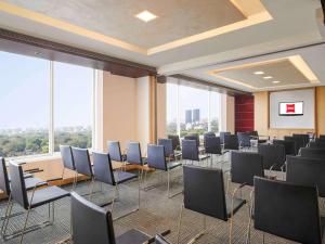 a room with rows of chairs in a room with windows at ibis Pune Viman Nagar - An Accor Brand in Pune