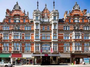 ein großes Backsteingebäude mit einer Flagge davor in der Unterkunft The Grand Hotel Leicester by The Unlimited Collection in Leicester