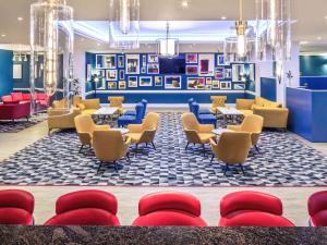 un hall avec des tables et des chaises ainsi qu'une salle d'attente dans l'établissement Mercure Swansea Hotel, à Swansea