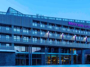 un grand bâtiment avec un panneau en haut dans l'établissement Mercure Blankenberge, à Blankenberge