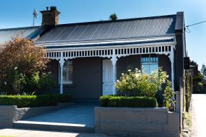 une maison avec une porte blanche et une terrasse couverte dans l'établissement Freddy's Boutique Villas, à Warrnambool