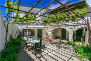 d'une terrasse avec une table et des chaises sous une pergola. dans l'établissement House Katica, à Grižane