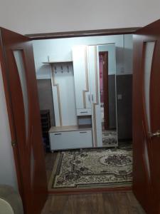 a mirror reflection of a room with a door and a rug at Комфортная квартира для гостей города in Qyzylorda