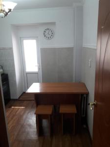 a room with a table and a clock on the wall at Комфортная квартира для гостей города in Qyzylorda
