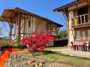 uma casa com flores vermelhas em frente em Hotel La Montoya em Curití