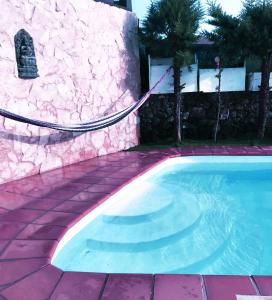 una piscina junto a una pared de piedra y una carga de carga de energía eléctrica en Lanzate en Tinajo