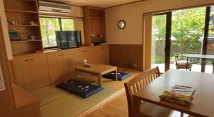 a living room with two tables and a television at のと海 in Nanao