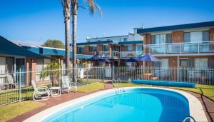 uma piscina em frente a um complexo de apartamentos em Surfside Merimbula Holiday Apartments em Merimbula