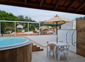 a patio with a table and chairs and a swimming pool at Pousada do Vovô Luiz in Conservatória