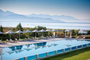 a large swimming pool with chairs and umbrellas at Buca Beachclub Resort in Messini