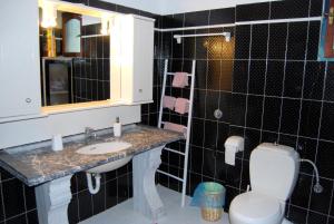 a bathroom with a sink and a toilet and a mirror at 5 bedrooms villa at Limnos 250 m away from the beach with sea view enclosed garden and wifi in Lemnos