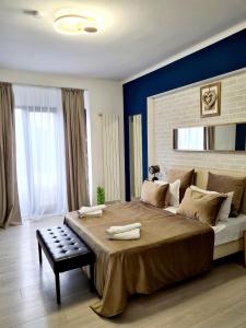 1 dormitorio con 1 cama grande y pared azul en Metropole Apartments - Old City, en Bucarest