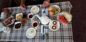 a table with plates of food on a table at Asman Guest House in Osh