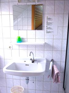 bagno con lavandino bianco e specchio di Landgasthaus Kaster a Valwig