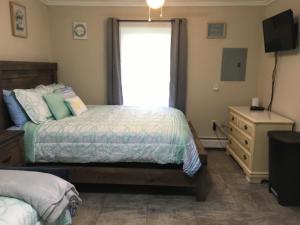 a bedroom with two beds and a television and a dresser at Just Like Being at Home- Newly Renovated Unit in North Troy