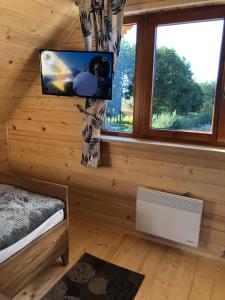 una habitación con TV y una cama en una cabaña en DOMEK POD LIMBAMI III en Kluszkowce