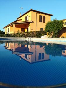 uma casa e uma piscina em frente a uma casa em Appartamento in Villa Santa Caterina em Frascati