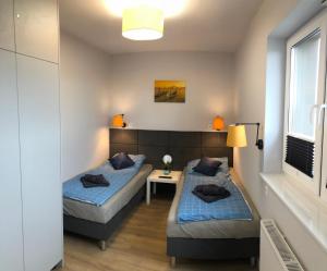 1 dormitorio con 2 camas y ventana en Klimatyzowany Apartament Wenecja z garażem podziemnym en Kielce