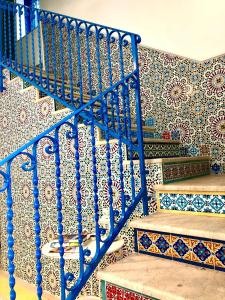 Una escalera de caracol azul en una habitación con azulejos en Sant'Agostino Suites & Rooms, en Mazara del Vallo