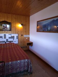 a bedroom with a bed and a painting on the wall at Les Saisies côté Bisanne appartement dans chalet LE Népal in Les Saisies
