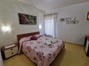 a bedroom with a bed with a pink bedspread at Astra in Agerola