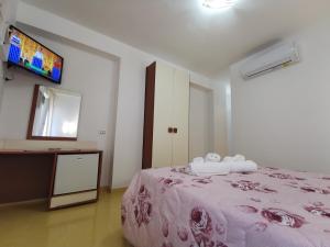 a bedroom with a bed and a tv on the wall at Astra in Agerola