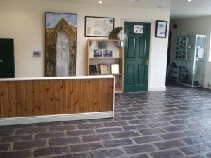 a room with a stone floor and a wooden fence at Brú na Dromoda/Dromid Hostel in Killeenleagh Bridge