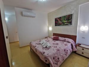 a bedroom with a pink bed with two stuffed animals on it at Astra in Agerola