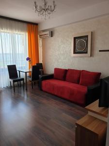 - un salon avec un canapé rouge et une table dans l'établissement Monaco Summerland Apartments, à Mamaia