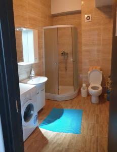 La salle de bains est pourvue d'un lave-linge et de toilettes. dans l'établissement Monaco Summerland Apartments, à Mamaia