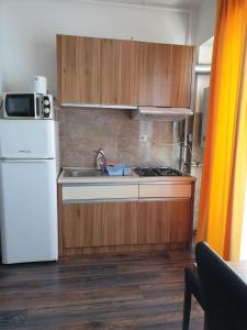 eine Küche mit einem weißen Kühlschrank und einem Herd Top-Backofen in der Unterkunft Monaco Summerland Apartments in Mamaia