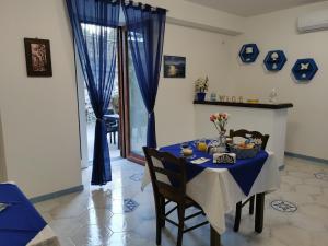 a dining room with a blue table and chairs at Astra in Agerola