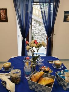 a table with a blue table cloth with bread and flowers at Astra in Agerola
