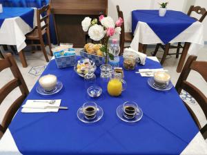 a blue table with cups and plates of food and drinks at Astra in Agerola
