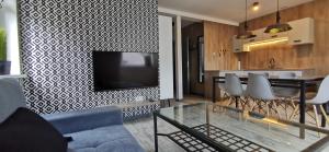 Televízia a/alebo spoločenská miestnosť v ubytovaní Apartamenty Majówka