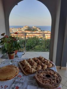 a table with pies and a view of the ocean at Olimpo in Diamante