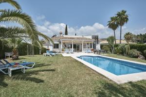 a villa with a swimming pool and a house at Villa Pinsapo in Estepona