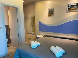 een slaapkamer met een bed met handdoeken erop bij Hotel Moderno - Bed & Breakfast in Cervia