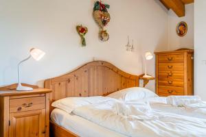 a bedroom with a bed and two lamps and a dresser at Dolomites Dream Arabba in Masarei
