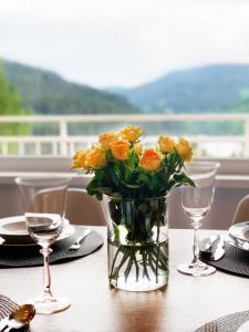 a vase of yellow flowers sitting on a table at Panorama 19 in Špindlerův Mlýn
