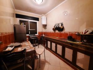 a kitchen with a counter and a table and a refrigerator at Appartement Tanger familles in Tangier