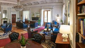 una sala de estar con muebles azules y una lámpara de araña. en Villa Royal, en Florencia